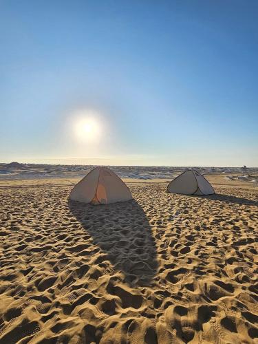 two tents in the sand on a beach at White Desert Safari With Camping in Bawiti