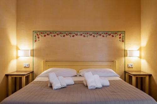 a bedroom with a bed with two pillows and two lamps at Rosaspina - Appartamento 4 in Capalbio