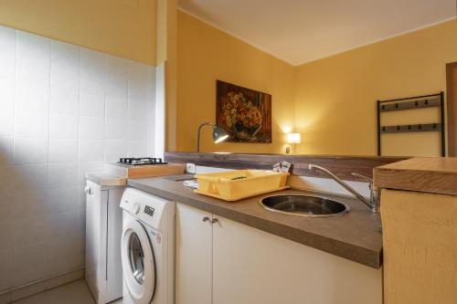 a kitchen with a sink and a washing machine at Rosaspina - Appartamento 4 in Capalbio
