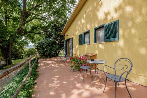 a patio with tables and chairs next to a building at Rosaspina - Appartamento 4 in Capalbio