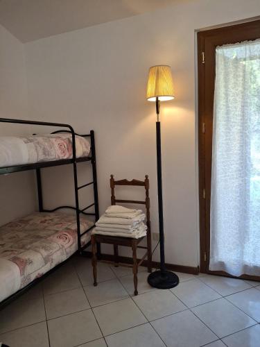 a room with a lamp and a chair and a bed at Agriturismo Le Vergare in Offagna