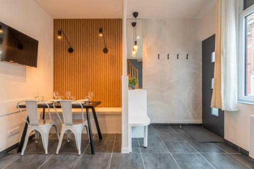 a dining room with a table and chairs at Maison 2 chambres proche du tram, parking gratuit in La Madeleine