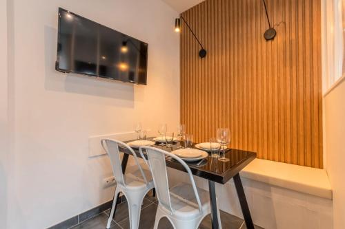 une salle à manger avec une table avec des chaises et une télévision dans l'établissement Maison 2 chambres proche du tram, parking gratuit, à La Madeleine