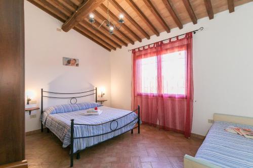 Un dormitorio con dos camas y una ventana. en Il Pino - appartamento Tiglio, en Cecina