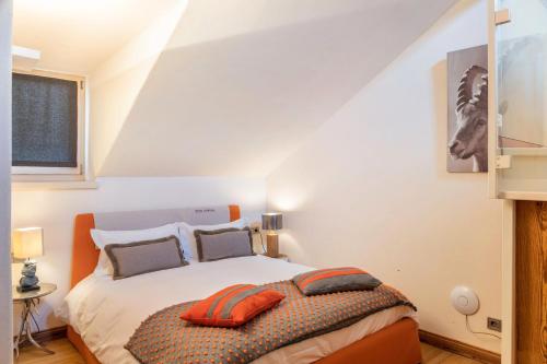 a bedroom with a bed with orange pillows on it at Haus Gabriel - Seefeld in Seefeld in Tirol