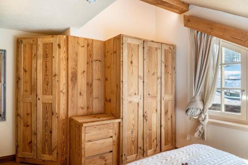 a bedroom with wooden cabinets and a bed and a window at Haus Gabriel - Seefeld in Seefeld in Tirol