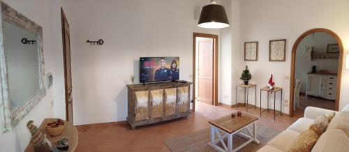 a living room with a couch and a tv in it at KiKi House Bracciano in Bracciano