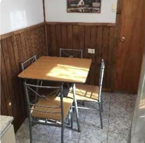 a wooden table and chairs in a room at Cabaña Venti in Bahia Inglesa