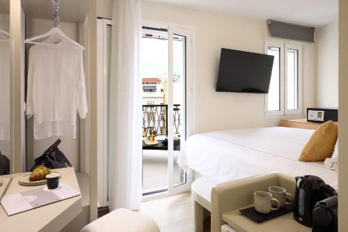 a hotel room with a bed and a balcony at AthenSun Luxury Suites in Athens