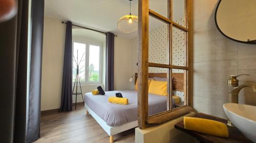 une chambre avec un lit, un miroir et un lavabo dans l'établissement Le Pavillon de Chasse, à Muttersholtz