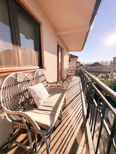 a balcony with two wicker chairs and a window at Apartments Aerodrom in Podgorica