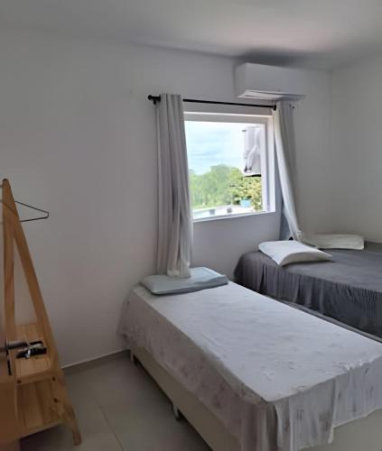 a room with two beds and a window at Panoramic Camarás Forest in Camaragibe