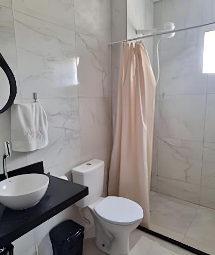 a bathroom with a toilet and a sink and a shower at Panoramic Camarás Forest in Camaragibe