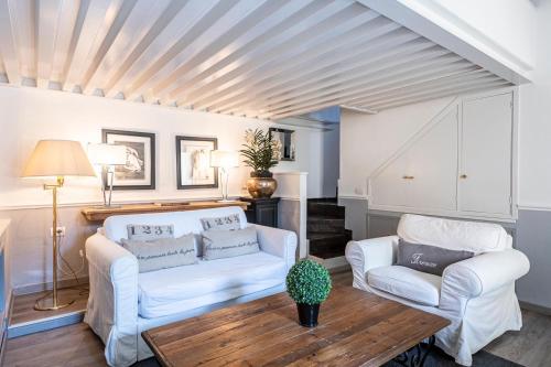 a living room with two white chairs and a table at Florence F&M Via Maggio in Florence