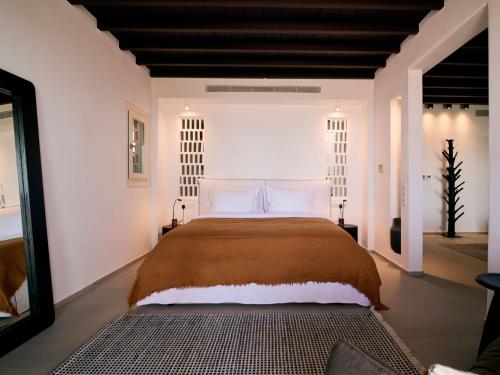a bedroom with a large bed and a mirror at Mykonos Rocks Villas & Suites in Mýkonos City