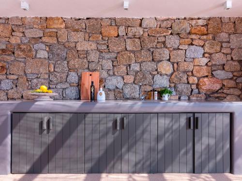 a stone wall in a kitchen with a counter at Mykonos Rocks Villas & Suites in Mýkonos City