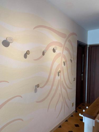 a wall with a painting of a tree on it at La Casa 44 in Soviore