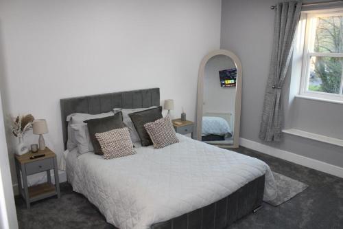 a bedroom with a large bed with pillows on it at Finlays at Holme in Holmfirth