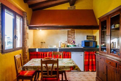 a kitchen with a table and chairs in a room at Le Gerlette - La Capanna in Braccagni