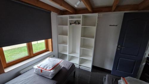 a bedroom with a bed and a window and a closet at Vissershuisje 89 te Wenduine in Wenduine