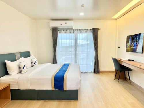 a hotel room with a bed and a desk at Air Diamond Hotel in Ban Nong Khong