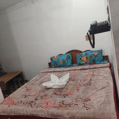 a bed with a white butterfly sitting on top of it at Hotel Relax Inn in Sonāmarg