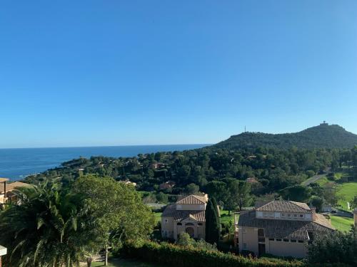 une vue d'une ville avec l'océan en arrière-plan dans l'établissement Cap Esterel - endroit magique entre mer et l'Esterel - agréable 2 pièces au gout du jour vue mer, à Saint-Raphaël