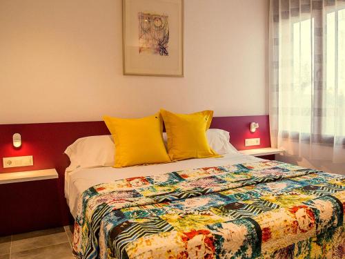 ein Schlafzimmer mit einem großen Bett mit gelben Kissen in der Unterkunft Ferienhaus in Torroella De Montgrí mit Privatem Pool in Torroella de Montgrí