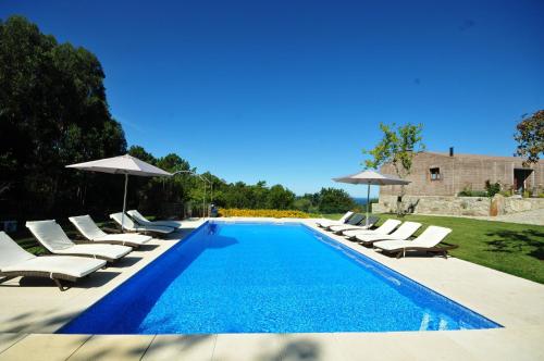 una piscina con lettini e ombrelloni di Ferienhaus Für 14 Personen In Afife ad Afife