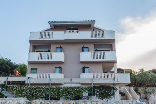 ein hohes weißes Gebäude mit Balkonen in der Unterkunft Ferienhaus in Ražanj mit Großem Garten in Ražanj