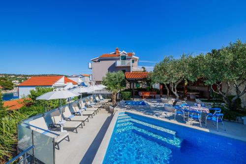 ein Pool in einem Hotel mit Stühlen und Sonnenschirmen in der Unterkunft Ferienhaus in Ražanj mit Großem Garten in Ražanj