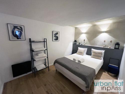 - une chambre avec un lit et une étagère avec des serviettes dans l'établissement Urban Flat 89 - Charming Central Flat, à Paris