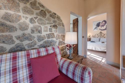 a living room with a couch and a stone wall at Il Pintello - Il Riccio in Massanera