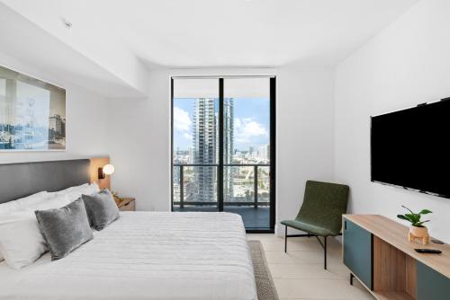 a bedroom with a large bed and a flat screen tv at Luxury 2-Bdrm Condo in the Heart of Downtown Miami in Miami