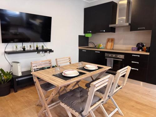 a kitchen with a wooden table with chairs and a television at La Dea Bendata in Rocca Priora