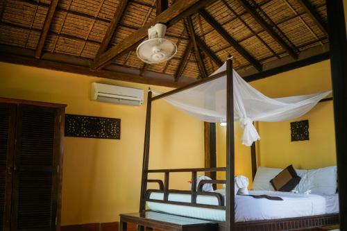 ein Schlafzimmer mit einem Himmelbett in einem Zimmer in der Unterkunft Mealea Resort in Kep