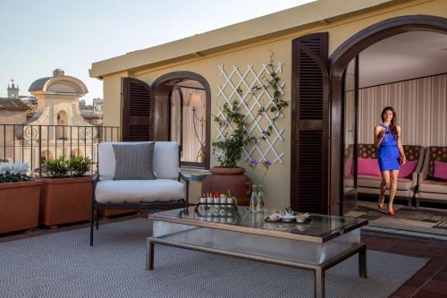 a woman standing on the balcony of a house at The Inn at the Spanish Steps Luxury Collection - The Inn at the Spanish Steps in Rome