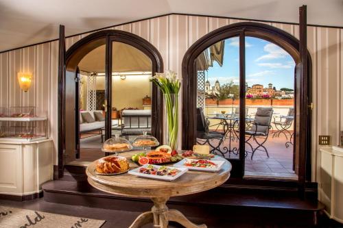 a living room with a table with food on it at The Inn at the Spanish Steps Luxury Collection - The Inn at the Spanish Steps in Rome