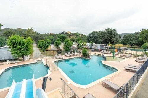 Una piscina con tumbonas y un resort. en Camping 3 étoiles - Piscine - ccaffbe, en Bormes-les-Mimosas