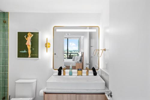a bathroom with a white sink and a mirror at Luxury 2-Bdrm Condo in the Heart of Downtown Miami in Miami