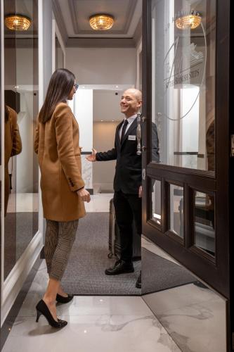 a man and a woman standing in front of a door at The Inn at the Spanish Steps Luxury Collection - The Inn at the Spanish Steps in Rome