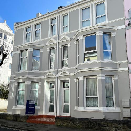 a white building on a street at Edgcumbe Guest House in Plymouth