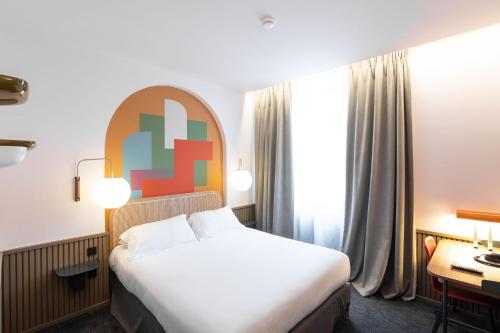 a hotel room with a bed and a desk at Hôtel Des Artistes in Lyon