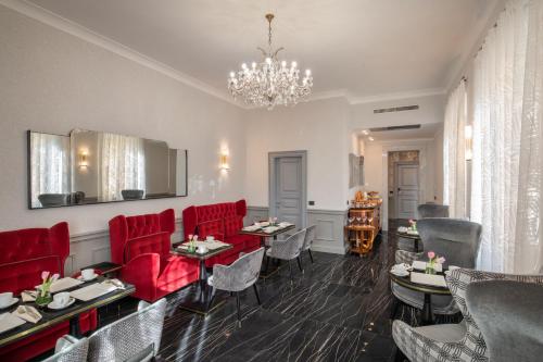 a dining room with red chairs and a chandelier at The Inn at the Spanish Steps Luxury Collection - The Inn at the Spanish Steps in Rome
