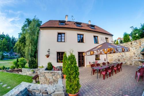 a house with a table and chairs in front of it at Rožmberk Royale Pension in Rožmberk nad Vltavou
