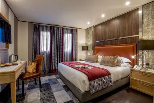 a hotel room with a bed and a desk at The Inn at the Spanish Steps Luxury Collection - The Inn at the Spanish Steps in Rome