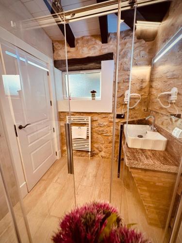 a bathroom with a sink and a glass door at La Quinta Luxury Palace in Arnuero