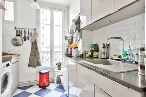 une cuisine avec un évier et une machine à laver dans l'établissement appartement cosy Montmartre, à Paris