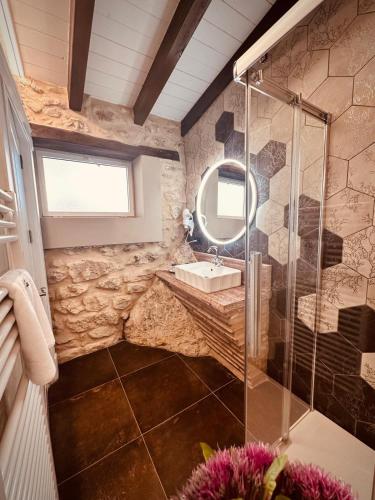 a stone bathroom with a sink and a mirror at La Quinta Luxury Palace in Arnuero