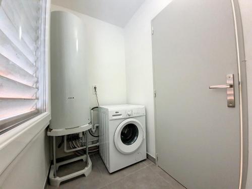 - un lave-linge et un sèche-linge dans une petite salle de bains dans l'établissement Beau T5 au cœur des Beaux Arts à Montpellier, à Montpellier